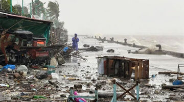 Seseorang berdiri di dekat puing-puing yang bertebaran akibat hujan lebat yang diperparah oleh Topan Super Ragasa, di Apalit, Provinsi Pampanga, Filipina, Selasa (23/9/2025). Foto: John Dimain/AFP
