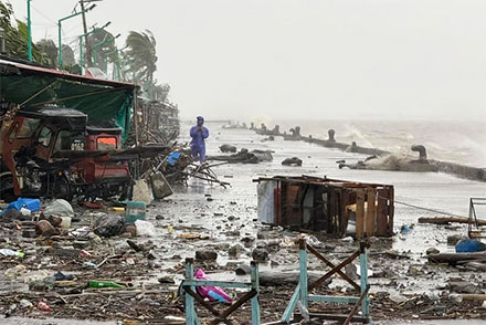 Seseorang berdiri di dekat puing-puing yang bertebaran akibat hujan lebat yang diperparah oleh Topan Super Ragasa, di Apalit, Provinsi Pampanga, Filipina, Selasa (23/9/2025). Foto: John Dimain/AFP
