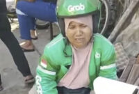 Saripah, ojol di Makassar menangis melihat motor miliknya dibakar massa tawuran, Senin (22/9/2025). Foto: Dok. Istimewa
