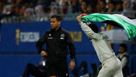 Ini adalah momen di mana seorang suporter tiba-tiba menghambur masuk lapangan Johan Cruyff Stadium. Foto: REUTERS/Albert Gea