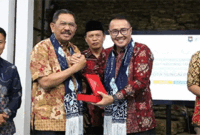 Wako Alfin menyerahkan plakat dan cenderamata berupa batik khas Sungai Penuh kepada tim verifikasi nasional.
