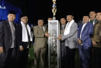Wabup Murison menyerahkan piala juara umum kepada camata Danau Kerinci Barat. (Ist)