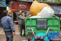Usman mengangkat rongsokan. (foto: dok: albrita.com)