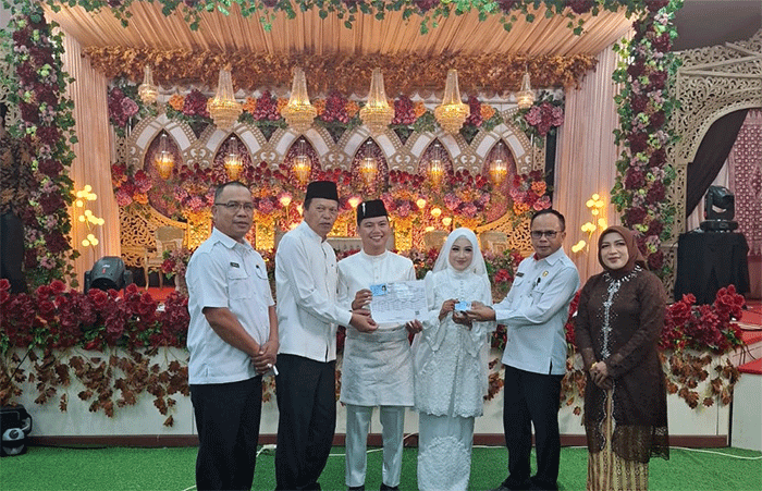 Wawako Azhar Hamzah, didampingi Sekretaris Dukcapil Asnadi, Meri Sumarni Kabid Pelayanan dan Kabid Pemanfaatan Data Siak Amrah memberikan