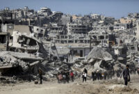 Sejumlah warga berjalan di dekat bangunan yang hancur akibat gencatan senjata Hamas-Israel di Jabalia, Jalur Gaza, Selasa (21/1/2025). Foto: Dawoud Abu Alkas/REUTERS
