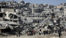 Sejumlah warga berjalan di dekat bangunan yang hancur akibat gencatan senjata Hamas-Israel di Jabalia, Jalur Gaza, Selasa (21/1/2025). Foto: Dawoud Abu Alkas/REUTERS