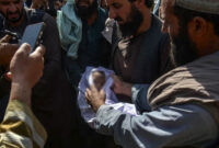 Sejumlah warga mengelilingi mayat bayi yang tewas di distrik Spin Boldak, Provinsi Kandahar, pada 16 Oktober 2025, sehari setelah bentrokan lintas batas antara Afghanistan dan Pakistan.  Foto: Sanaullah SEIAM / AFP
