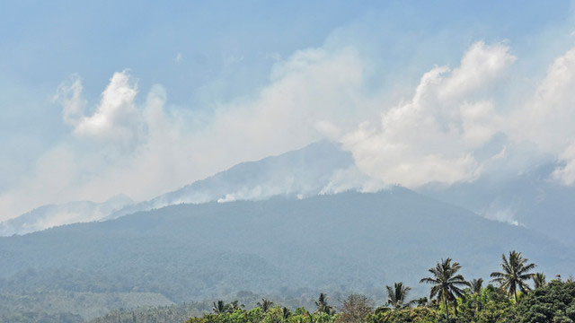 Asap kebakaran di kawasan hutan Pelawangan Senaru Gunung Rinjani membubung ke udara terlihat dari Desa Senaru, Kecamatan Bayan, Lombok Utara, NTB, Senin (21/10) Foto:  ANTARA FOTO/Ahmad Subaidi