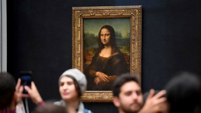 Wisatawan berfoto di depan lukisan Mona Lisa di Paris.