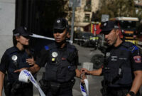 Polisi memasang garis polisi di area kejadian sementara petugas tanggap darurat merespons lokasi runtuhnya bangunan di Madrid, Spanyol, pada Selasa (7/10/2025). Foto: Manu Fernandez/AP Photo