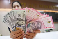 Foto Arsip - Petugas menunjukkan mata uang rupiah dan dolar AS di Ayu Masagung Money Changer, Jakarta. ANTARA FOTO/Dhemas Reviyanto/foc.