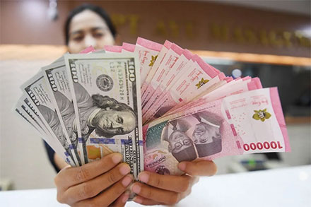 Foto Arsip - Petugas menunjukkan mata uang rupiah dan dolar AS di Ayu Masagung Money Changer, Jakarta. ANTARA FOTO/Dhemas Reviyanto/foc.
