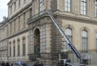 Petugas kepolisian Prancis berdiri di samping lift barang yang digunakan oleh para perampok untuk masuk ke Museum Louvre di Quai Francois Mitterrand, Paris, Minggu (19/10/2025). Foto: Dimitar Dilkoff/AFP