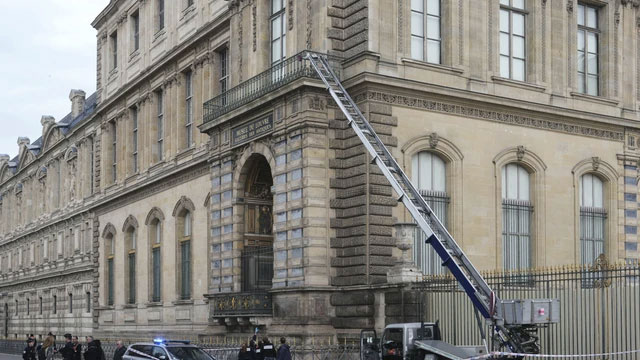 Petugas kepolisian Prancis berdiri di samping lift barang yang digunakan oleh para perampok untuk masuk ke Museum Louvre di Quai Francois Mitterrand, Paris, Minggu (19/10/2025). Foto: Dimitar Dilkoff/AFP