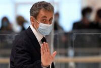 Mantan presiden Prancis Nicolas Sarkozy melambai ketika dia meninggalkan ruang sidang. Foto: Bertrand Guay/AFP
