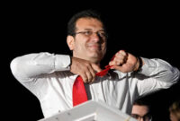 Walikota Istanbul dan kandidat oposisi utama Partai Rakyat Republik (CHP) Ekrem Imamoglu melepas dasinya di depan para pendukung yang merayakan di luar gedung kotamadya utama setelah pemilihan kota di seluruh Turki, di Istanbul (31/3) Foto: Yasin Akgul/AFP
