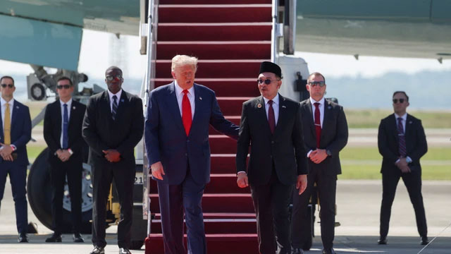 Perdana Menteri Malaysia Anwar Ibrahim menyambut Presiden Amerika Serikat Donald Trump saat tiba di Bandara Internasional Kuala Lumpur di Sepang, Malaysia, Minggu (26/10/2025). Foto: Evelyn Hockstein/REUTERS