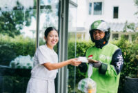 Pemilik Lunch For My Husband (LFMH), Yori Atira memberikan paket sandwich kepada mitra driver GoSend. Foto: Dok. Gojek
