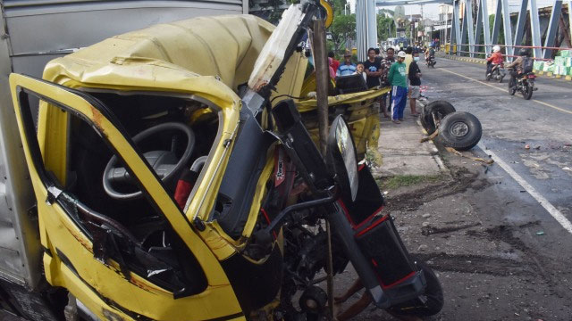 Warga melihat kondisi truk yang hancur akibat kecelakaan. Foto: ANTARA FOTO/Siswowidodo
