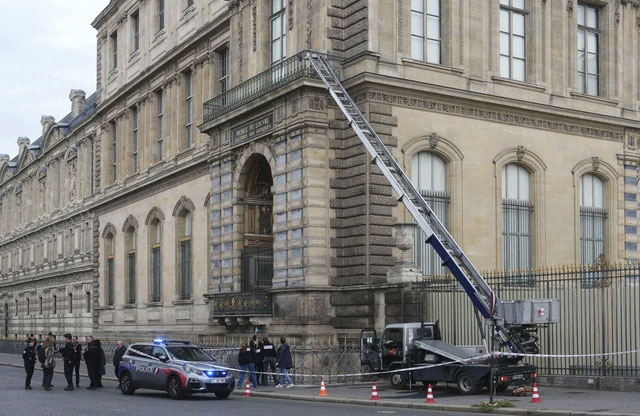 Petugas kepolisian Prancis berdiri di samping lift barang yang digunakan oleh para perampok untuk masuk ke Museum Louvre di Quai Francois Mitterrand, Paris, Minggu (19/10/2025). Foto: Dimitar Dilkoff/AFP
